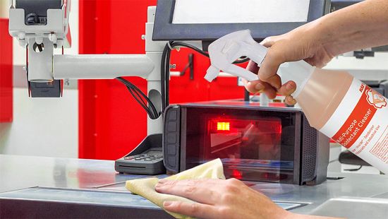 Ecolab branded multi-purpose disinfectant cleaner being sprayed onto checkout equipment.